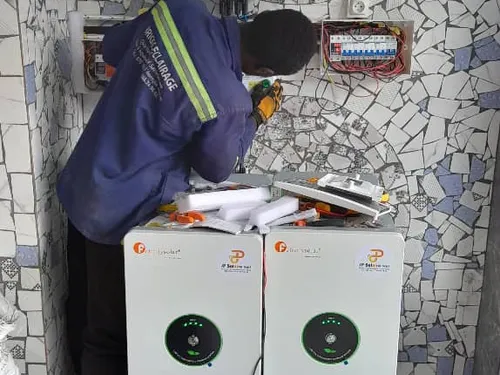 JP Solaire inverter and two batteries installed on a tiled wall